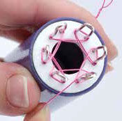 Wire being wrapped around the spokes of the knitter